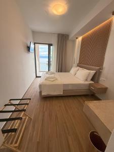 a bedroom with a bed and a large window at Pension Remvi in Loutra Edipsou +6 photos