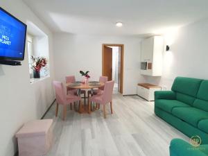 a living room with a table and a green couch at Apartment Irene in Sečovlje