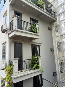 un edificio bianco con balconi e piante di T Home Balcony Homestay a Hanoi