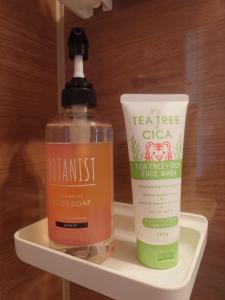 a bottle of sunscreen and a container of soap on a shelf at Chiba Gateway House in Chiba