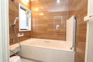 a bathroom with a bath tub and a toilet at Chiba Gateway House in Chiba