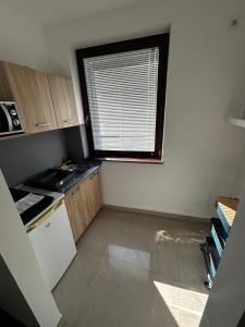 a small kitchen with a window and a sink at Lexi Classic 2 in Hajdúszoboszló