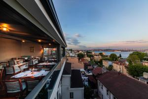 a restaurant with tables and chairs on a balcony at Triton Hotel in Istanbul