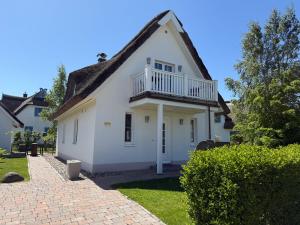 una casa bianca con un balcone sopra di Reethaus Sonnenwiese, Haus am Meer mit eingezäuntem Garten, Hunde herzlich willkommen a Glowe