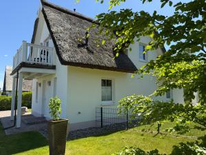 una casa bianca con il tetto nero di Reethaus Sonnenwiese, Haus am Meer mit eingezäuntem Garten, Hunde herzlich willkommen a Glowe