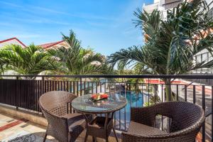 a table and chairs on a balcony with palm trees at ELC Boutique Hoi An Hotel in Hoi An