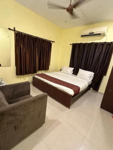 a bedroom with a bed and a couch at Five stones By Earth Hotel Vadapalani in Chennai