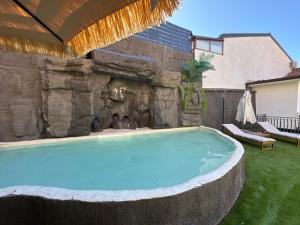 a swimming pool in a yard with a stone wall at Casa Calipso in Catania