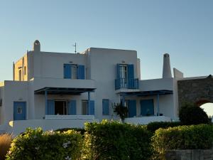una casa blanca con ventanas azules y un edificio en Sea View Serenity Paros, en Ampelas