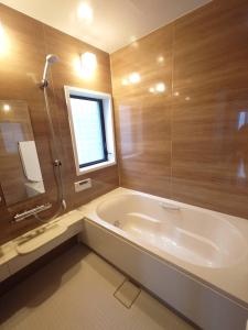 a large bathroom with a tub and a shower at Chiba Gateway House in Chiba