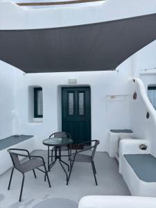 a room with a table and chairs and a bed at Manias Fira Residences in Fira