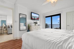 a white bedroom with a large bed and a balcony at Luxury Oceanfront Condo with Pools, Hot Tub, Gym & Grill by myBeach Vacation Rentals in Myrtle Beach +34 photos