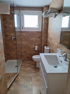a bathroom with a shower and a sink and a toilet at Rallye Hotel in L'Escala