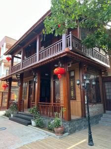 a wooden building with a balcony on a street at Mai Vien Homestay & restaurant in Cư Chinh