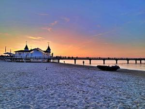 una playa con un muelle y un barco en la arena en Ferienzimmer Gleißner, en Ahlbeck