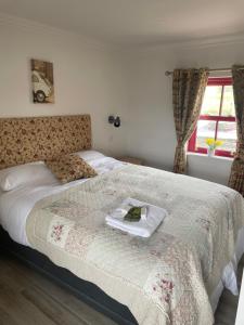una camera da letto con un letto con un libro sopra di Dun Aengus Cottage on the Cliffs of Moher a Liscannor
