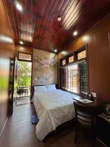 a bedroom with a bed and a desk and a window at Mai Vien Homestay & restaurant in Cư Chinh
