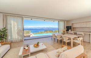 a living room with a table and a large window at Lovely Home In Preko With Sauna in Preko