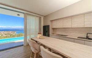 a kitchen with a large table and a large window at Lovely Home In Preko With Sauna in Preko