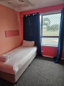 ロックハンプトンにあるRockhampton Court Apartmentのベッドと窓のある小さな寝室