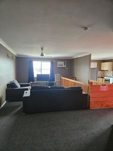 ロックハンプトンにあるRockhampton Court Apartmentのリビングルーム(ソファ2台付)、キッチンが備わります。