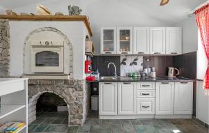 een keuken met een stenen open haard en witte kasten bij Gorgeous Home In Zirje With Wifi in Žirje