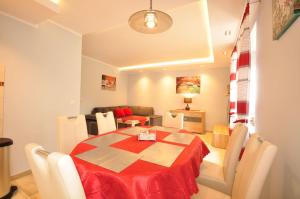 a dining room with a red table and chairs at Apartament LENA III Deluxe in Kowary