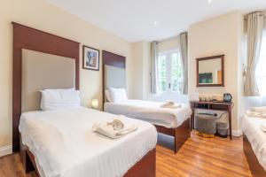 En eller flere senge i et værelse på Belmont Hotel