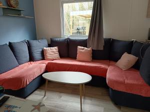 a living room with a blue couch with red cushions at Paradis in Piriac-sur-Mer