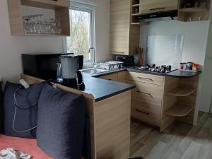 a kitchen with wooden cabinets and a counter top at Paradis in Piriac-sur-Mer