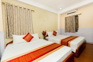 a bedroom with two beds and a window at Vuon Tao Dan Hotel - Trung Tâm Thành Phố Gần Chợ Bến Thành in Ho Chi Minh City