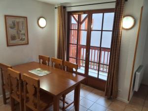 a dining room with a wooden table and a window at Les Estives de Cauterêts in Cauterets