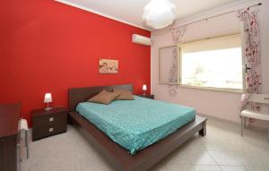 a red bedroom with a bed and a window at Cozy Apartment In Santa Croce Camerina in Santa Croce Camerina