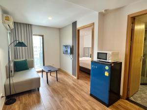 a hotel room with a couch and a microwave at Pentafield City Residence in Amphoe Phra Khanong