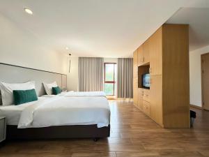 a bedroom with a large bed and a television at Pentafield City Residence in Amphoe Phra Khanong