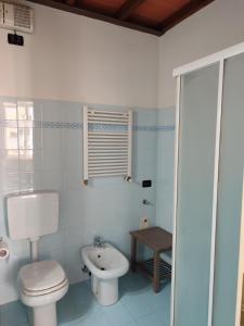 a white bathroom with a toilet and a sink at A casa di Raffaella in Parma +14 photos