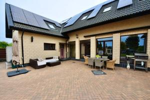 a house with a patio with solar panels on it at Amber dream Karkle in Karklė