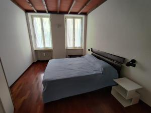 a bedroom with a bed and two windows at A casa di Raffaella in Parma