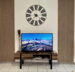 Un gran reloj en la pared encima de un televisor. en CityLife, en Millau