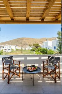 two chairs and a table on a patio with a view at THIRAMNA Apts KYTHNOS in Mérikhas +36 photos