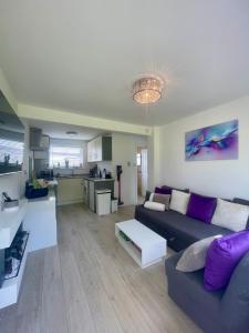 a living room with a couch and a table at Look no further Gorgeous newly renovated contemporary chalet Sandown Bay Holiday Centre in Sandown