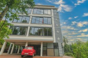 a red car parked in front of a building at Boutique Swaastig GOA in Calangute