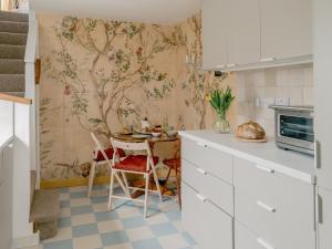 a kitchen with a table and a wall mural at Rose Garden Maisonette in Falmouth