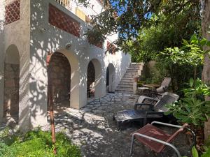 a patio with chairs and a building with arches at Villa Tricia Cannes in Cannes