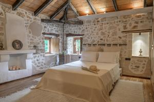 a bedroom with a bed with a hat on it at The Millers Room at Neromilos Watermill in Monastirákion
