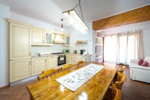 a kitchen and dining room with a wooden table at Green Residence Bados Mare in Olbia