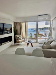 a living room with a couch and a tv at VOULIAGMENI ON THE BEACH in Athens +16 photos