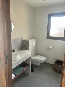 a bathroom with a white sink and a toilet at Appartement vue mer Vulpaghja 01 in Cargèse +32 photos