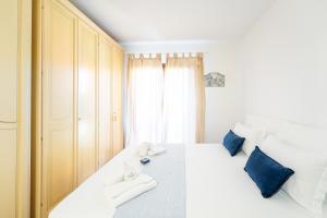 a bedroom with a large white bed with blue pillows at Green Residence Bados Mare in Olbia +13 photos