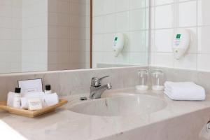 a bathroom counter with a sink and a mirror at Wyndham Garden Donaueschingen in Donaueschingen
